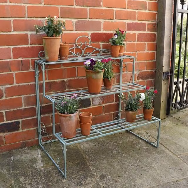 Melody Maison Three Tier Lacquered Metal Plant Theatre Stand in Sage Green and Dark Blue