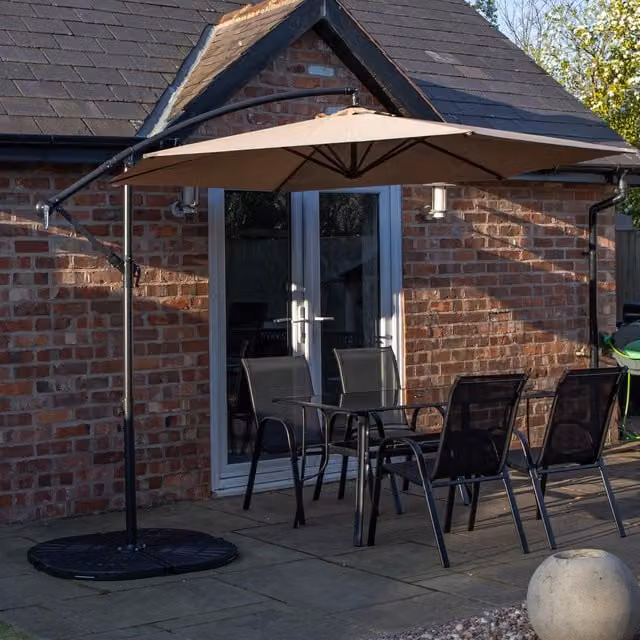 Samuel Alexander Modern Black Outdoor 4 Person Glass Top Table and Chairs Set with Beige Banana Parasol