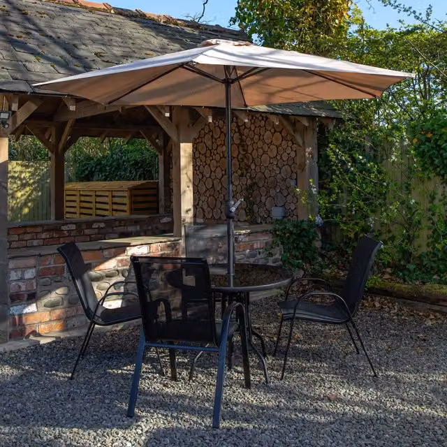 Samuel Alexander Round Glass Top Patio Dining Set with Beige Parasol and Base in Black
