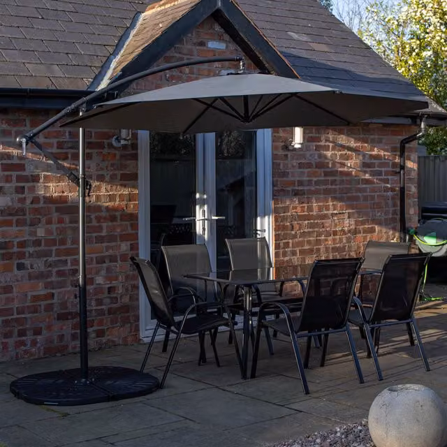 Samuel Alexander 6 Person Glass Top Dining Set with Black Metal Chairs and Grey Banana Parasol with Base