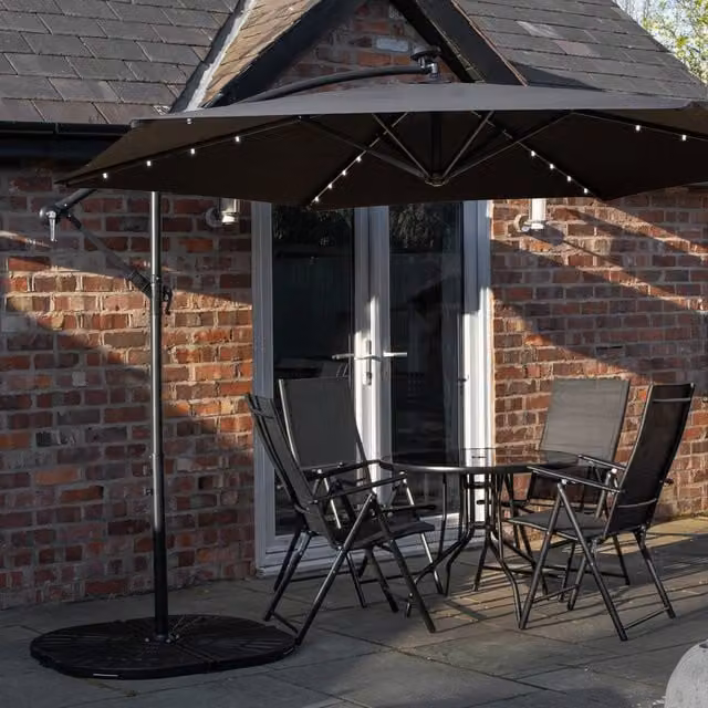 Samuel Alexander 4 Person Round Glass Top Garden Dining Set with Black Banana Lit Parasol and Base in Black and White