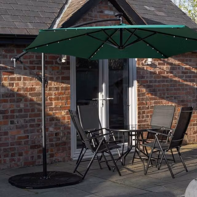 Samuel Alexander 4 Person Round Glass Top Garden Dining Set with Green Banana Lit Parasol and Base in Black